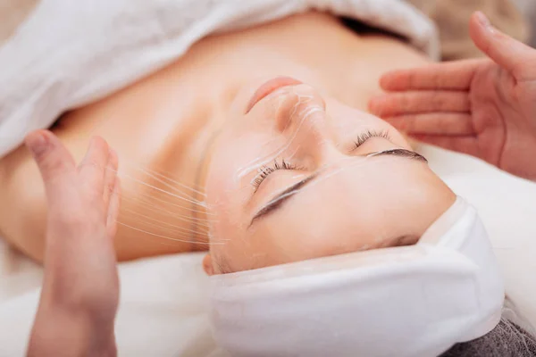 Agradável jovem mulher desfrutando de seu procedimento facial — Fotografia de Stock