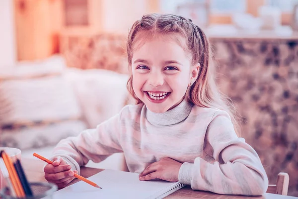 Lachende meisje met stijlvolle pigtails grapje vanwege haar onduidelijk schrijven — Stockfoto