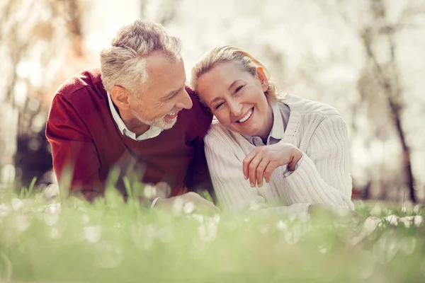 Glückliches grauhaariges Paar, das zusammen im Gras liegt — Stockfoto