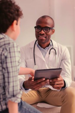 Genç ve konsantre bir doktor çocuk hastalar taleplerini dinliyor