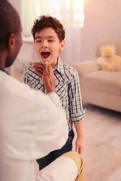 Niño mostrando sus dientes a su médico — Foto de Stock