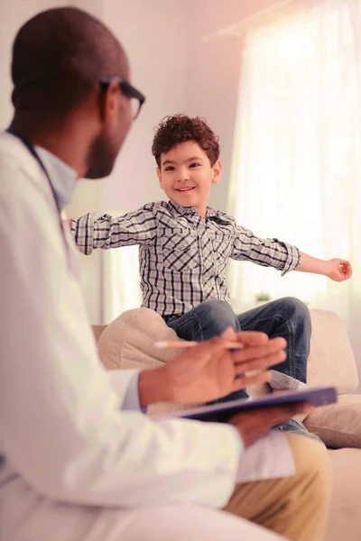 Begeistertes Kind kommuniziert mit seinem professionellen Arzt — Stockfoto