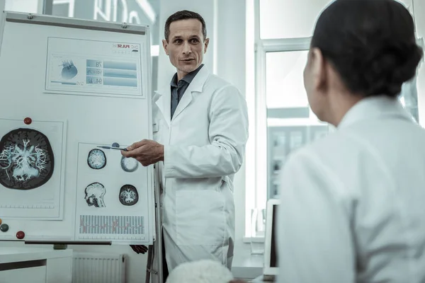 Профессиональный врач-мужчина указывает на фото с МРТ — стоковое фото