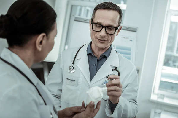 Médico masculino con gafas claras apuntando al modelo cardíaco — Foto de Stock