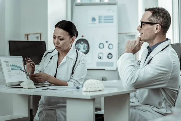 Busy medical scientist pointing on the screen with information