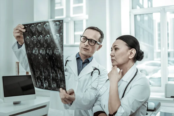 Un par de especialistas médicos mirando incomprensiblemente el hueso de la rodilla — Foto de Stock