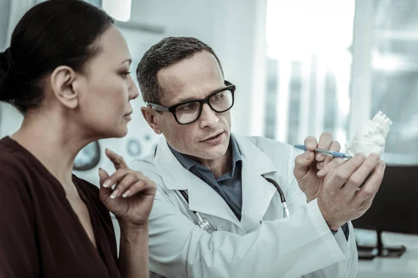 Interessierter Patient blickt aufmerksam auf das weiße Herz — Stockfoto