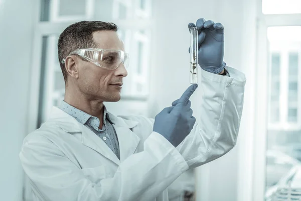 Usmívající se výzkumník v jasné brýle drží zkumavky — Stock fotografie