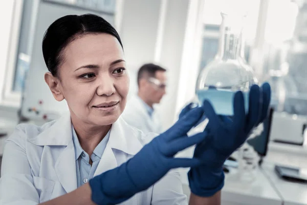 Naukowiec trzymając kolbę chemicznych cieczy — Zdjęcie stockowe
