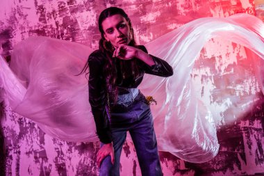 Pembe duvara karşı duran güzel genç kadın