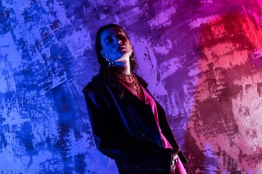 Renkli arka plan üzerinde duran güzel zarif kadın