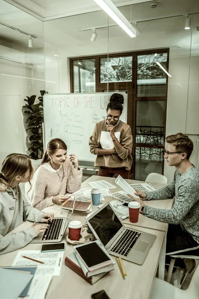 Estudiantes de posgrado usando computadoras portátiles preparándose para una lluvia de ideas —  Fotos de Stock