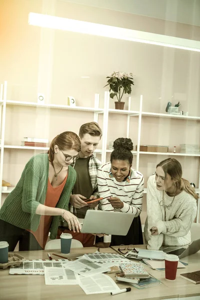 Cuatro estudiantes inteligentes activos viendo webinar educativo juntos — Foto de Stock