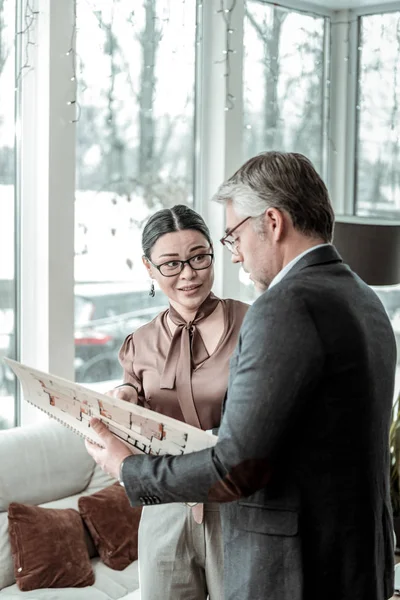 Dunkelhaarige elegante Frau in brauner Satinbluse, die unsicher wirkt — Stockfoto