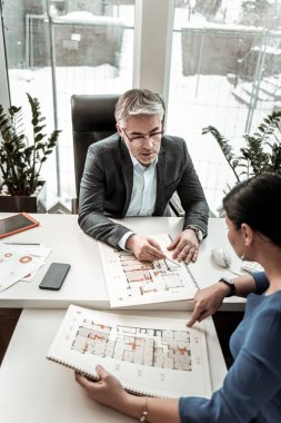 Proje detayları meslektaşı ile tartışırken gözlük gri saçlı ciddi adam