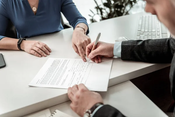 Donna con un orologio sulla mano che mostra il luogo per la firma al dipendente — Foto Stock