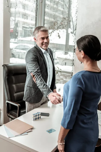 Tall grey-haired handsome man in eyeglasses meeting a new employee — Stock Photo, Image