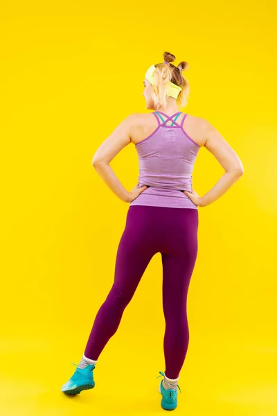 Kobieta nosi jasne legginsy i stanik, ciesząc się sport — Zdjęcie stockowe
