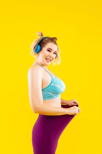 Young woman with earphones feeling proud after losing kilos — Stock Photo, Image