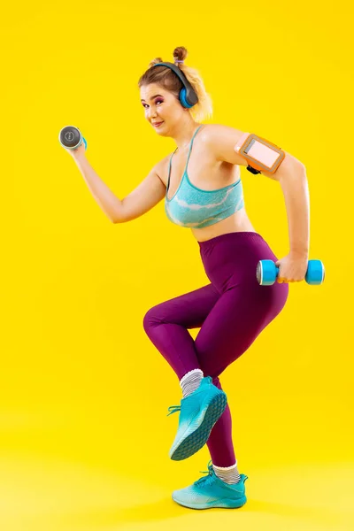 Kobieta nosi kolorowe ubrania, ćwiczenia z ciężarkami ręka — Zdjęcie stockowe