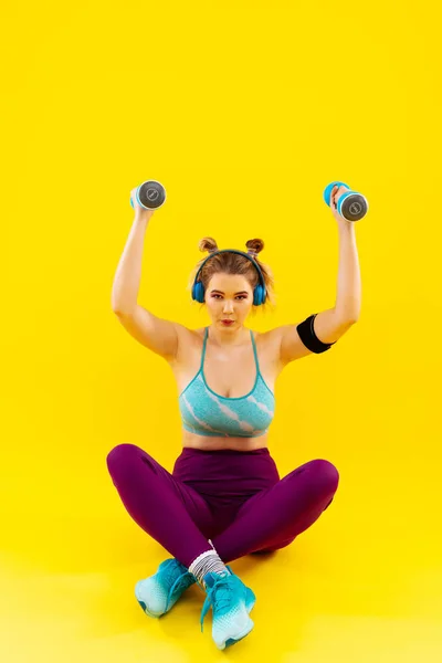 Mujer perdiendo peso sentada en el suelo y haciendo ejercicios — Foto de Stock