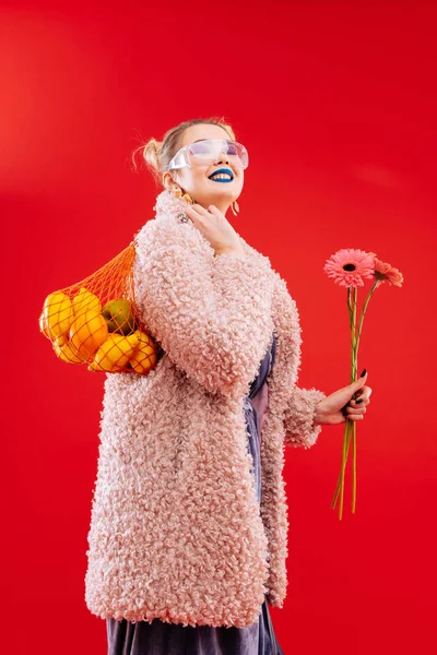 Femme aux cheveux blonds avec lèvres bleues sac à ficelle avec fruits — Photo