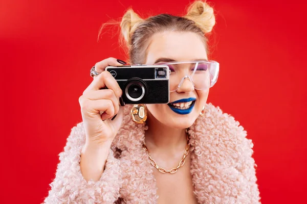 Mulher com lábios azuis e tons de olhos rosa usando câmera — Fotografia de Stock