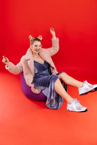 Bloger fashion mengenakan sepatu kets bergaya duduk di kursi beanbag — Stok Foto