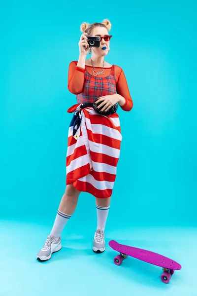 Mujer de cabello rubio con bandera sobre su cintura haciendo foto — Foto de Stock