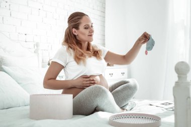 Neşeli genç hamile bayan çorap farklı renkteki yetiştirme