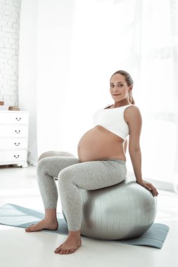 Üzerinde gri Pilates topu eğitim sırasında oturan sportif çekici Bayan