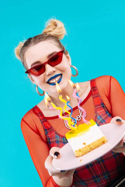 Блондинка с ярким макияжем смотрит на праздничный торт — стоковое фото
