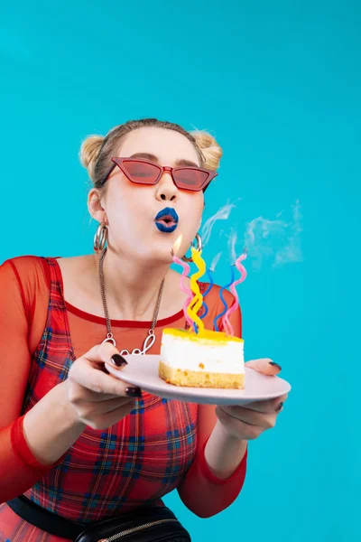 Glada födelsedagsbarnet blåsa ljusen på hennes läckra kaka — Stockfoto