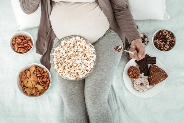 Schwangere in bequemer Kleidung im Bett liegend — Stockfoto