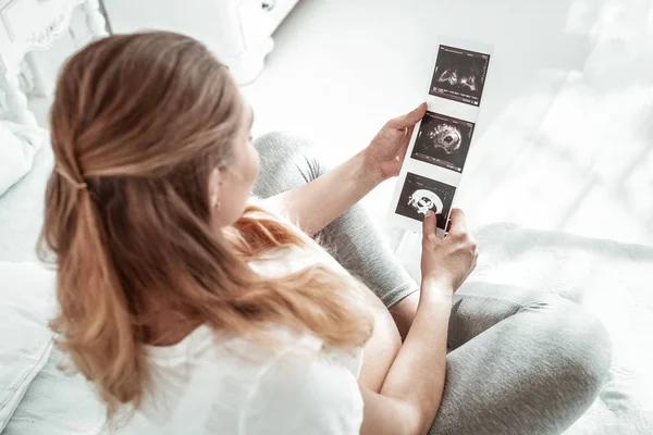 Çapraz ayaklı oturan ışık saçlı hamile kadın — Stok fotoğraf