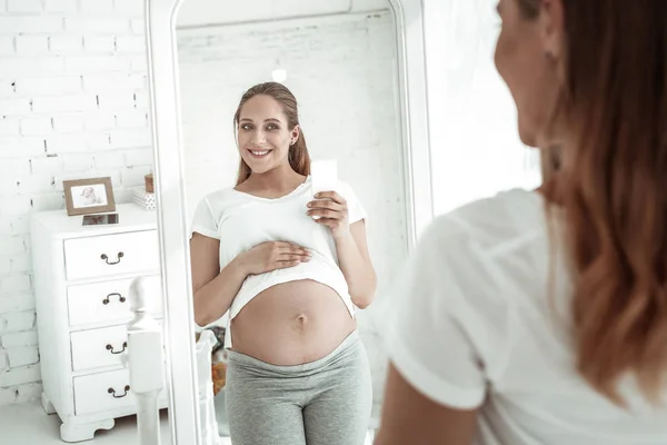 白い t シャツを上げる広い笑顔で晴れやかな長い髪の女 — ストック写真