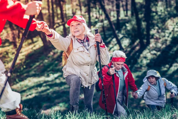 Femme retraitée prenant la main de son fils tout en marchant tous ensemble — Photo