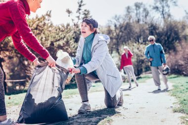 Emekli erkekler ve kadınlar genç kadın orman Temizleme katılmadan