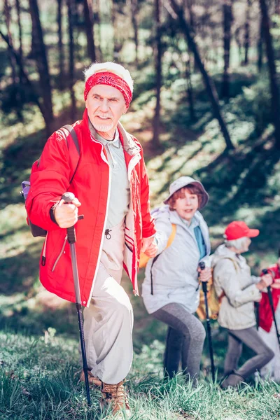 Homme retraité portant une veste rouge randonnée en famille et entre amis — Photo