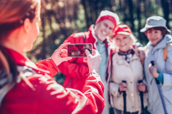 Three retired people posing for photo while hiking in forest — Stock Photo, Image