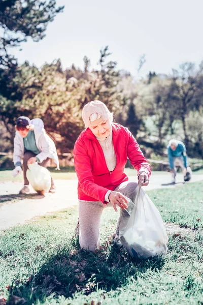 Mujer jubilada participando en la campaña de limpiar el parque — Foto de Stock