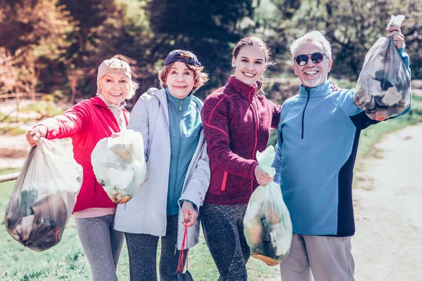 Bejaarde vrouw het dragen van de beenkappen en jas nest verzamelen — Stockfoto