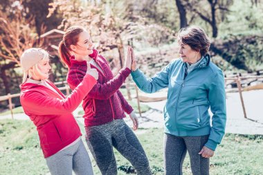 Etkin modern emekli kadın için yüksek beş veren genç kanepe