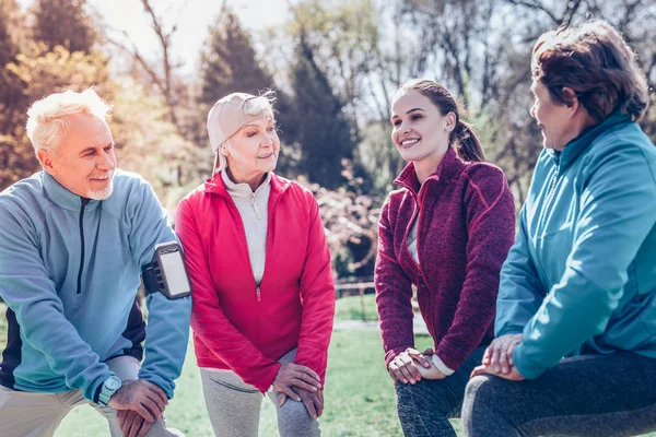 Hombres y mujeres jubilados haciendo deporte junto con entrenador — Foto de Stock