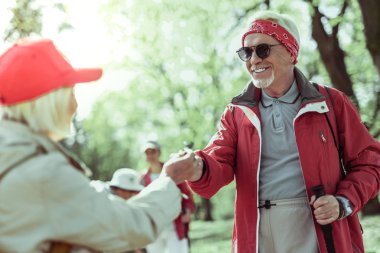 Şık yaşlı adam ortağı ile ormanda yürüyor