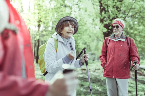 Femme âgée parlant émotionnellement tout en marchant dans la forêt — Photo