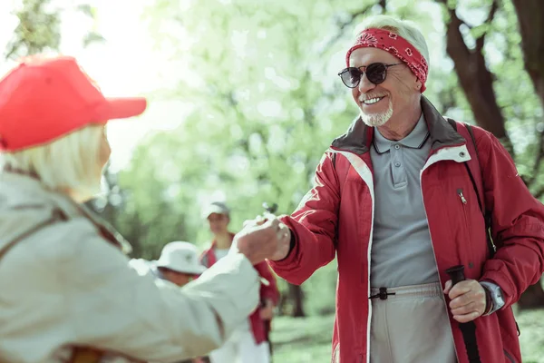 Şık yaşlı adam ortağı ile ormanda yürüyor