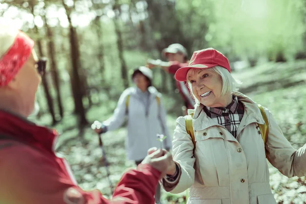 Oudere lachende vrouw wandelen in het bos met haar partner — Stockfoto