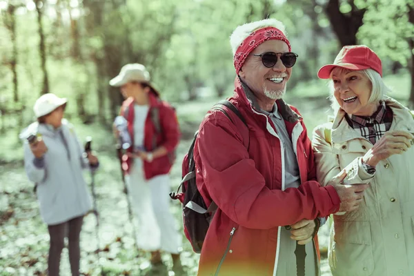 Aktív idős emberek költés idő séta az erdőben — Stock Fotó