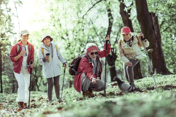 Tourists attracting a bird in the forest — Stock Photo, Image